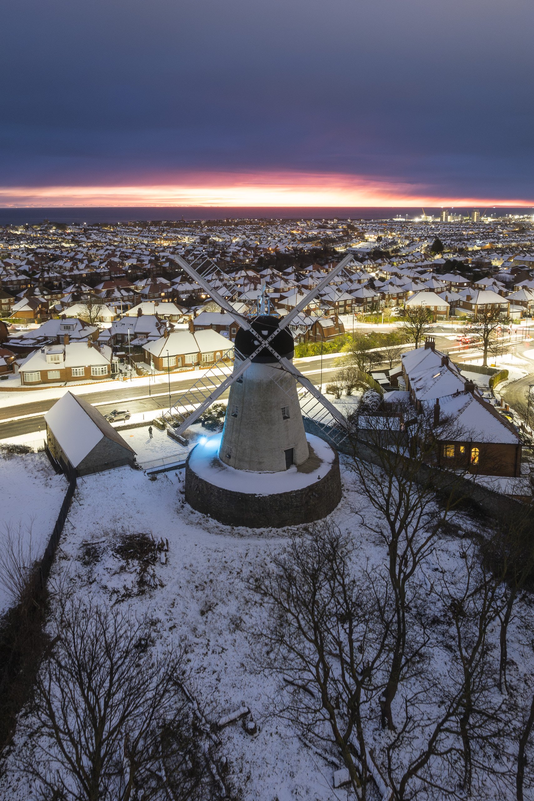 Aerial view of Fulwell Mill at dusk with snow on the ground